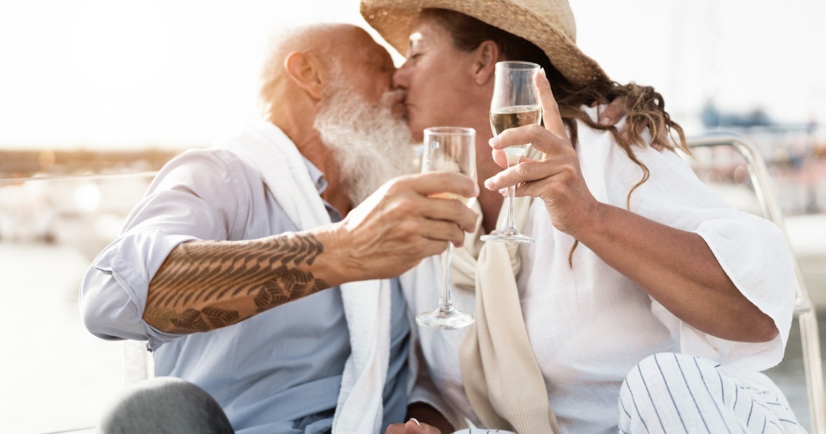 senior couple kissing while holding champagne flutes
