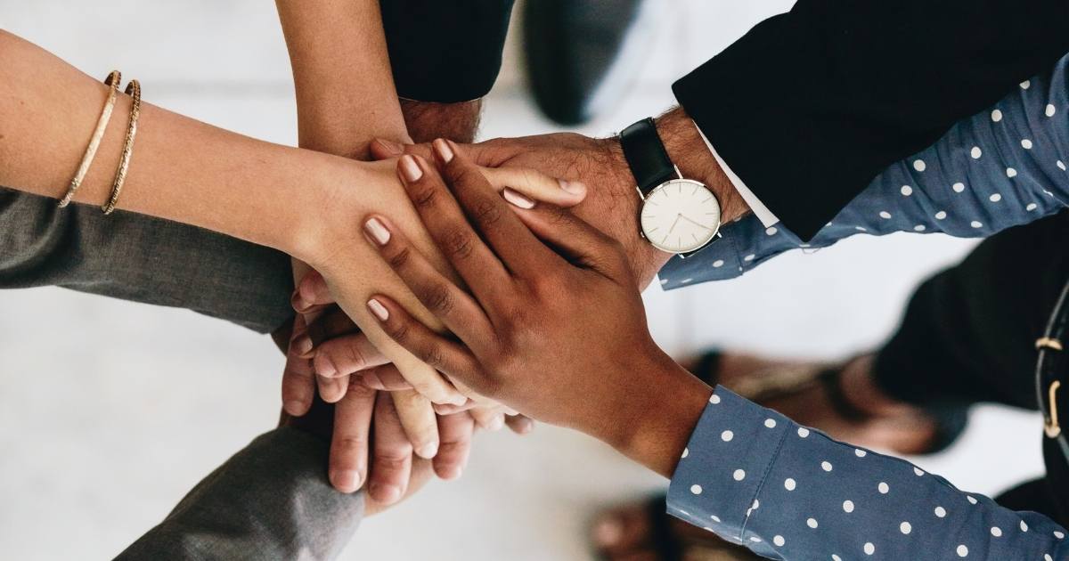 matchmaking team's hands together in a team huddle.