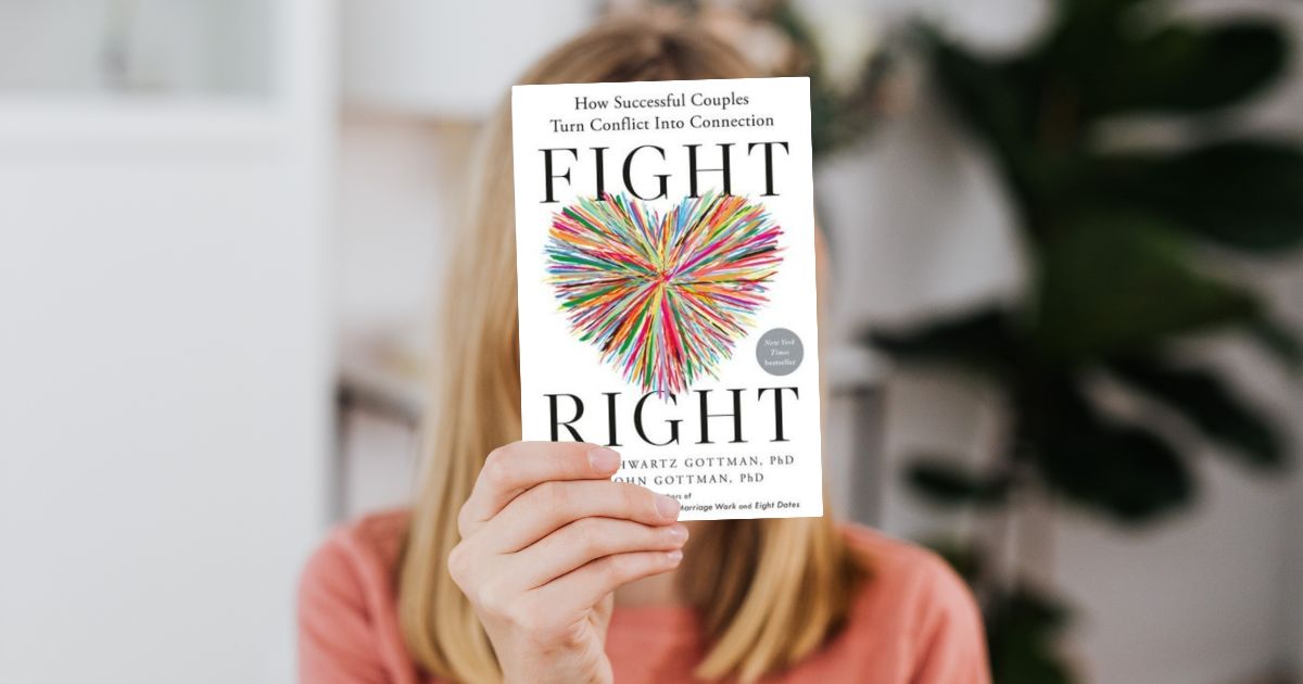 A woman holding a copy of Fight Right, one of the relationship books recommended by our matchmakers