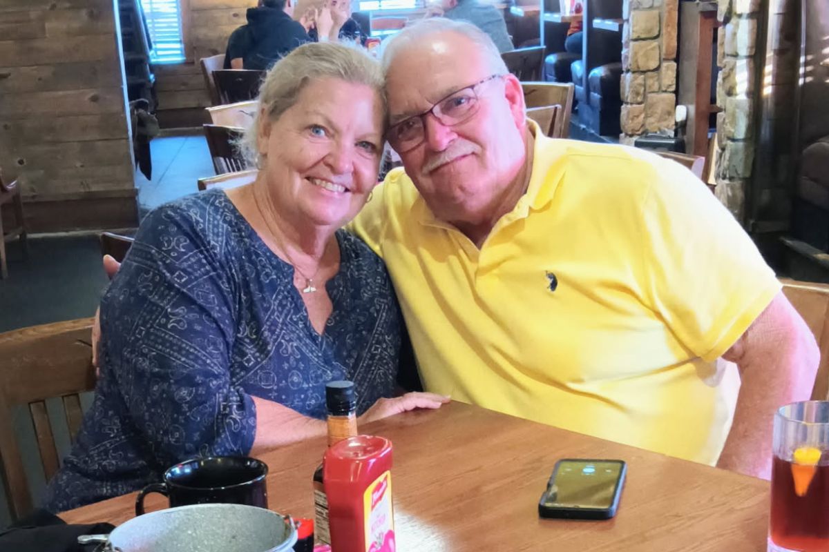 Mike and Cathy posing for a photo at a restaurant table.