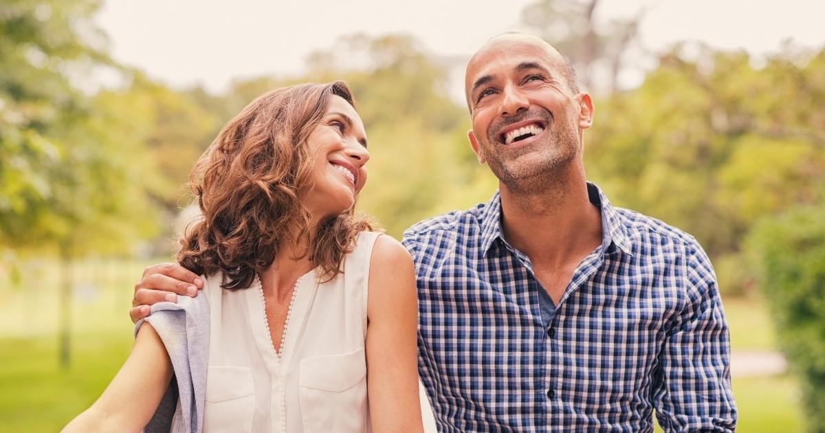 A man and woman smiling happily and showing healthy relationship qualities
