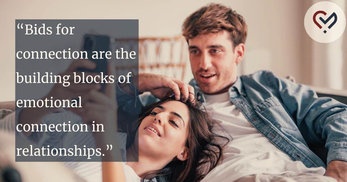 Relaxed romantic couple laughing together at a cell phone, responding positively to bids for connection through shared attention.