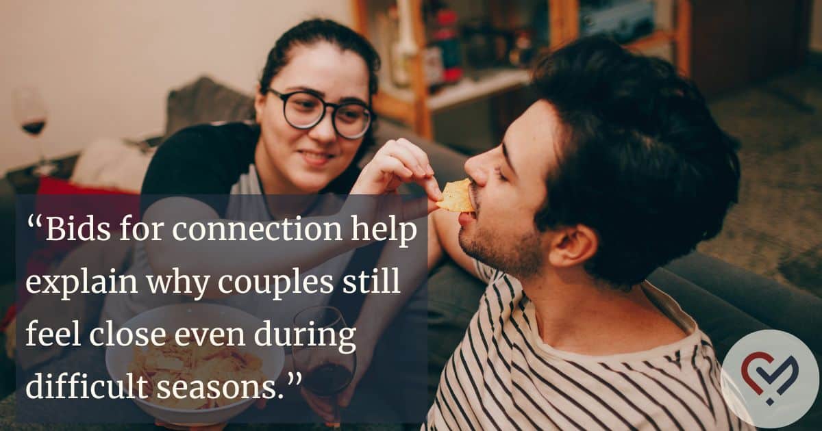 Couple laughing while playfully feeding each other chips, demonstrating positive responses to bids for connection and healthy communication