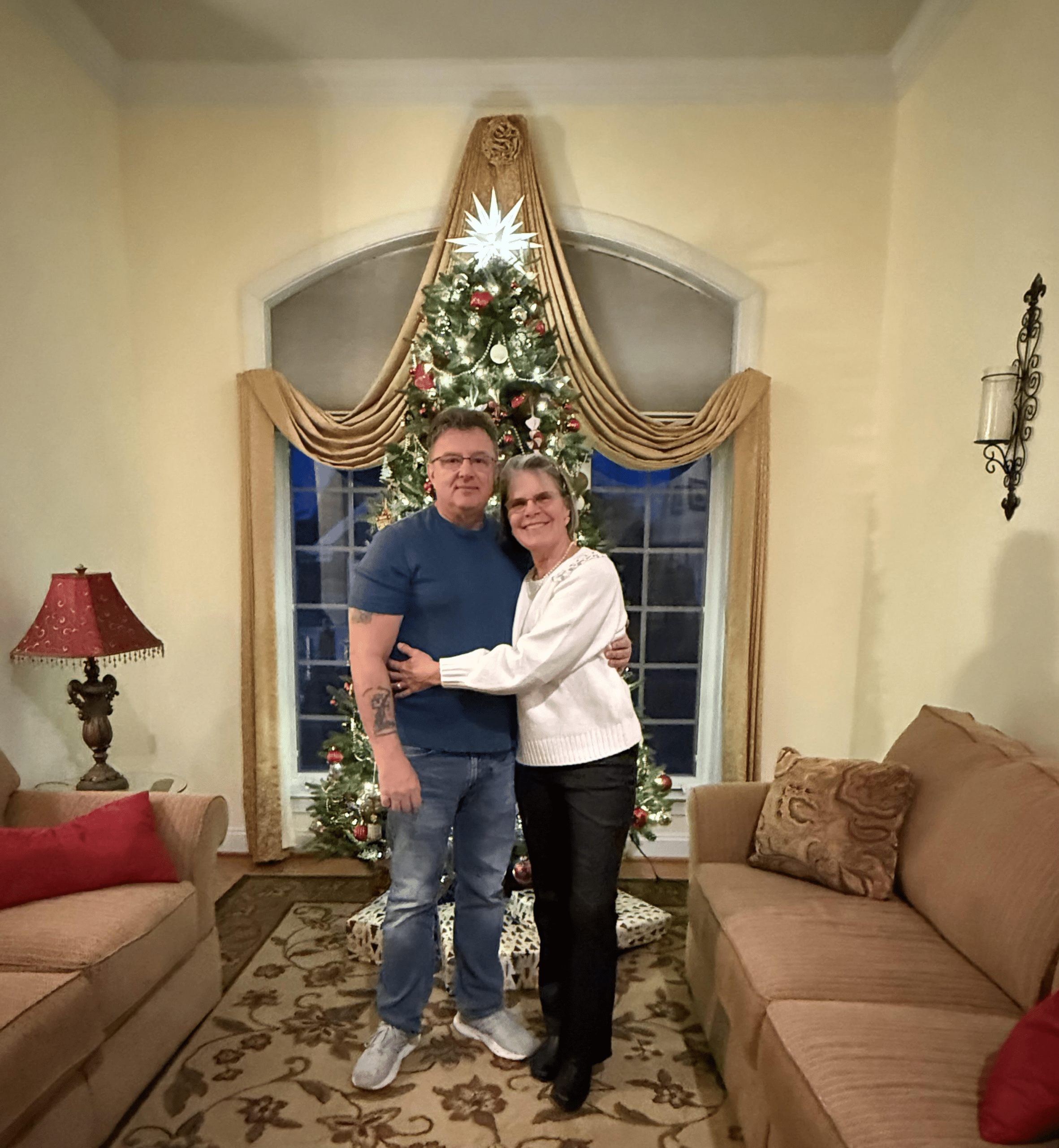 Real TMC clients Brian and Joan in front of a Christmas tree