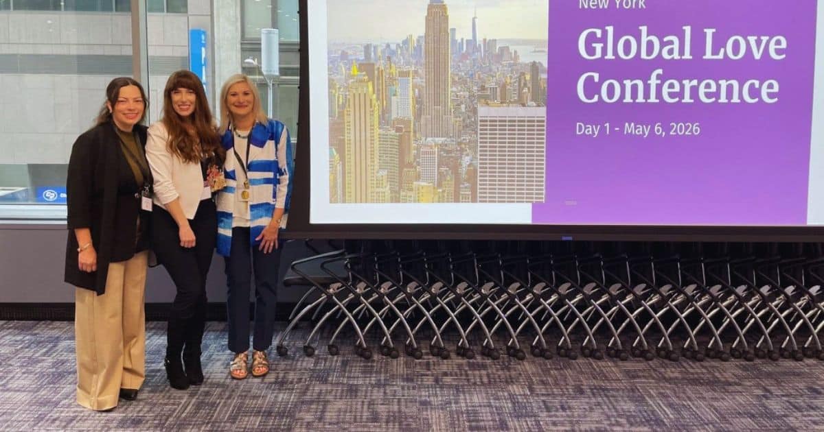 Kathrine Wilson, Heather Drury, and Dr. Teri Orbuch standing in front of a screen that says Global Love Conference